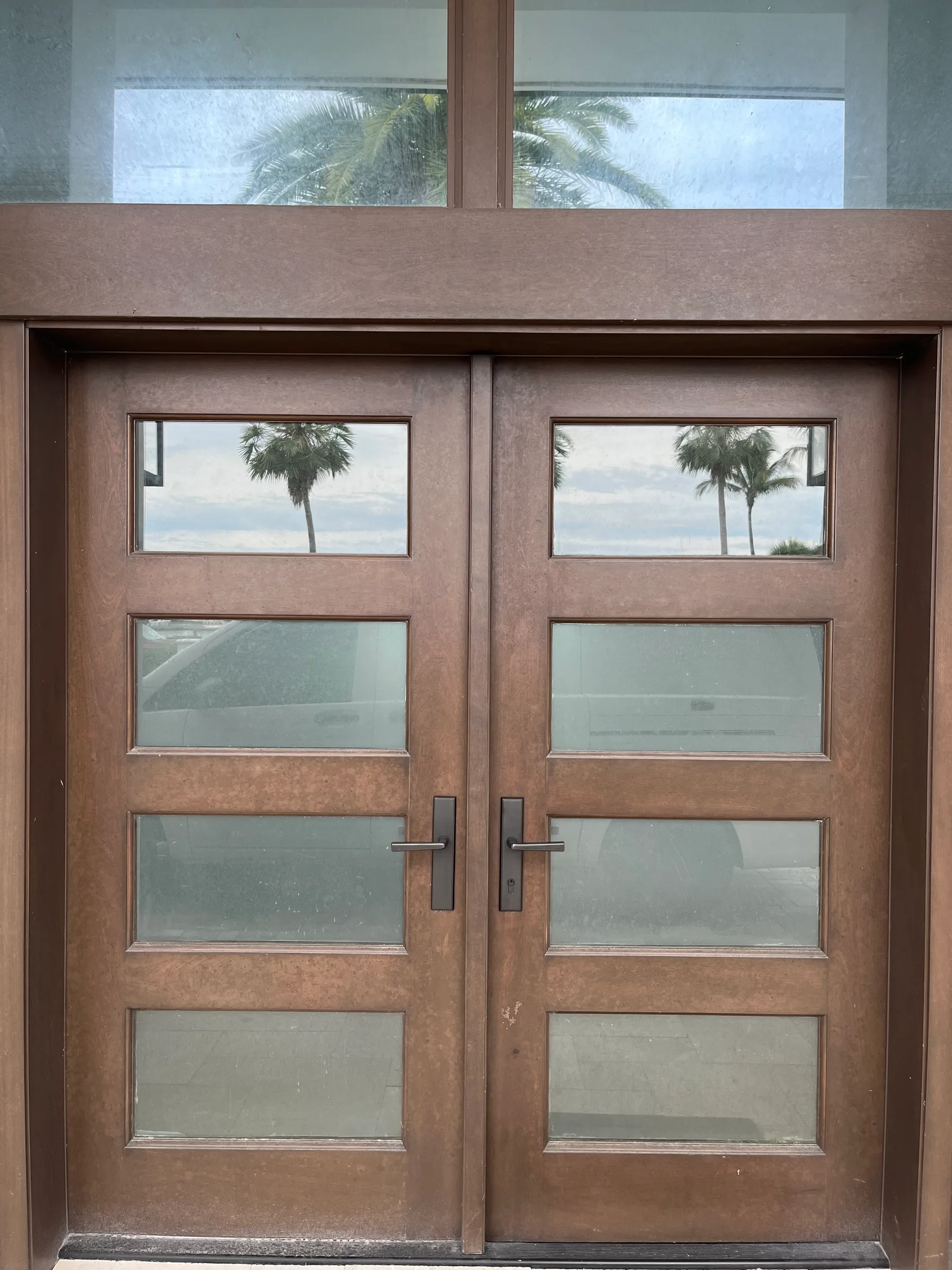 Beautiful double glass-panel entry doors with bronze levers installed by Lockhart Locksmith in Sarasota