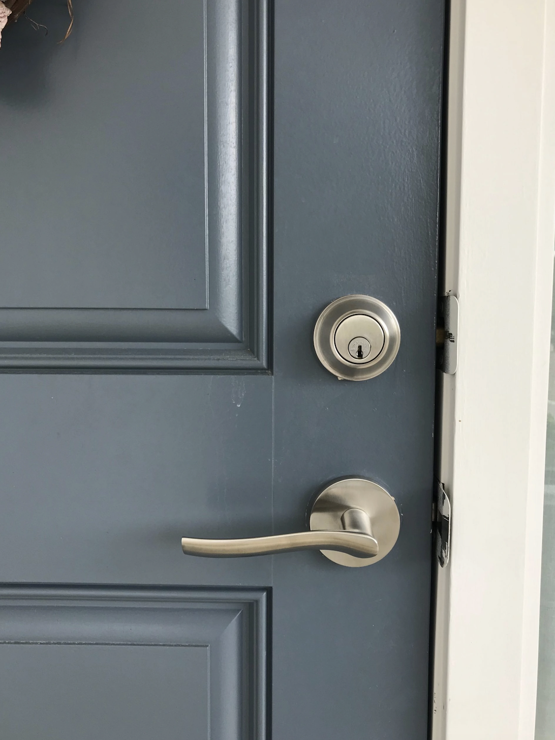 Lever and deadbolt on slate blue door